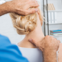 partial view of chiropractor stretching neck of woman during appointment in hospital