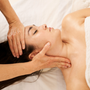 woman receiving a facial massage in the area of the cervicals