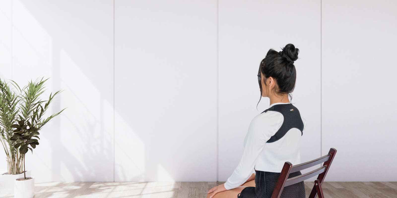 Woman sitting in a chair using a posture strap, how to improve posture 