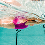 woman swimming underwater in swimming pool with blue water