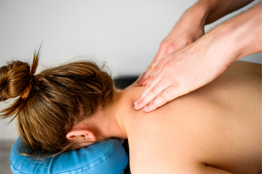Girl during neck and shoulders massage in spa salon. Masseur hands doing care body therapy procedure for young woman wellness and relaxation.