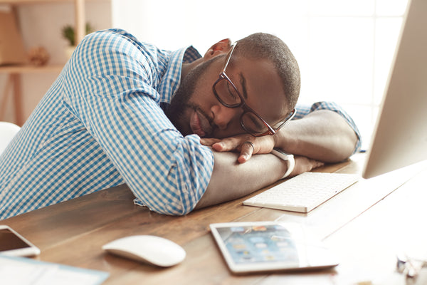 Taking a break. Tired afro american man in glasses sleeping at his working place at home. Afro american businessman feeling exhausted and sleeping at work. Freelance. Home office workplace