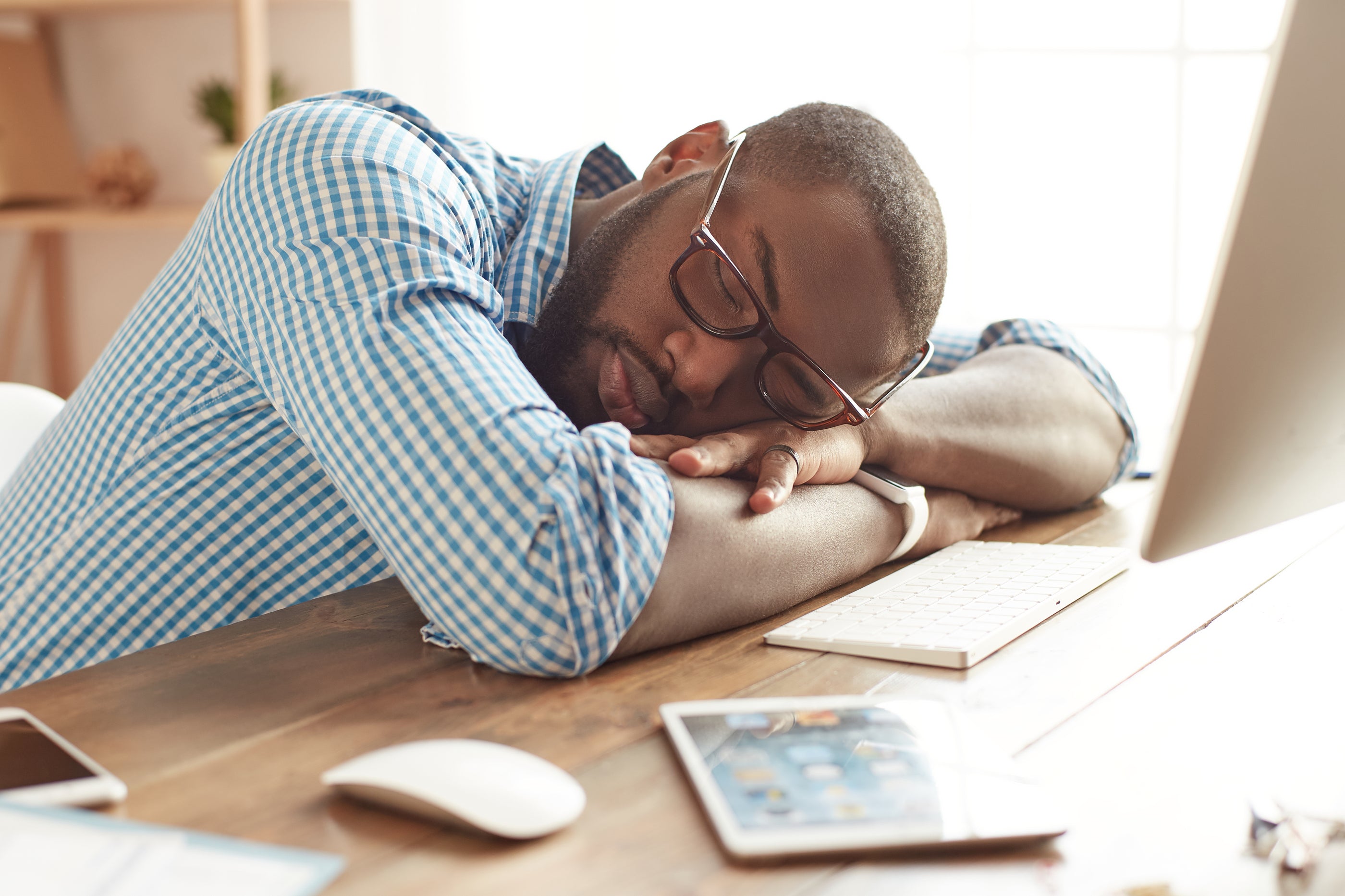 Taking a break. Tired afro american man in glasses sleeping at his working place at home. Afro american businessman feeling exhausted and sleeping at work. Freelance. Home office workplace