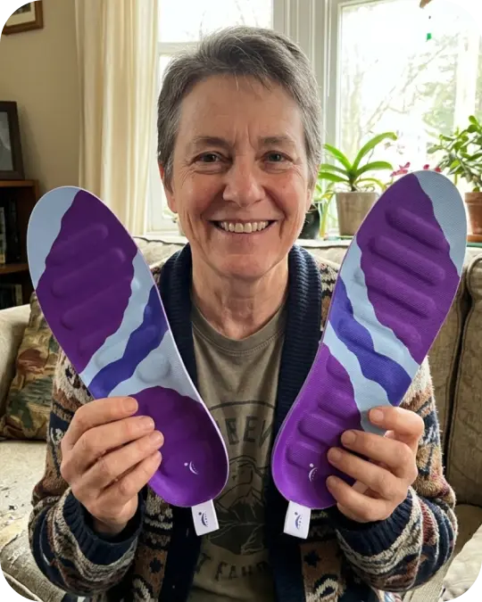 Customer holding a pair of RegenRx insoles.